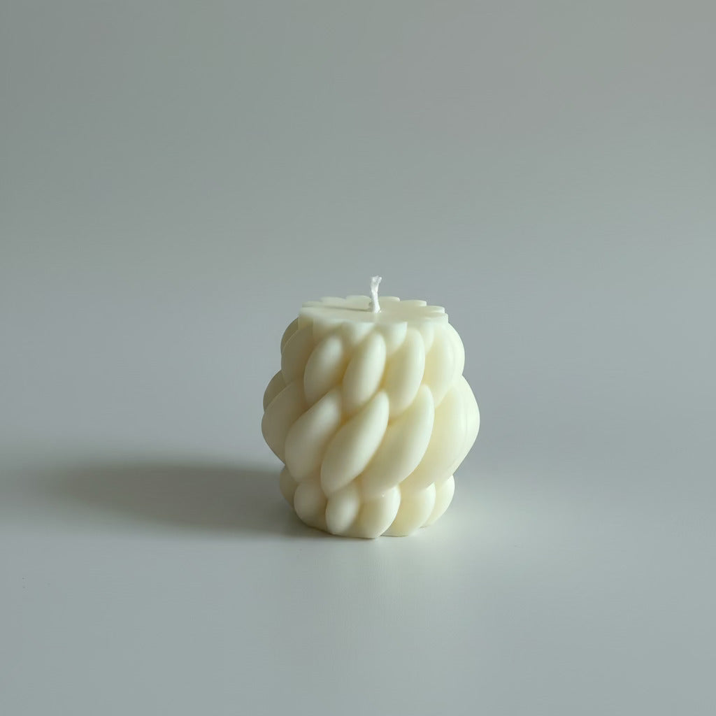 Bougie parfumée artisanale tressée crème sur fond blanc