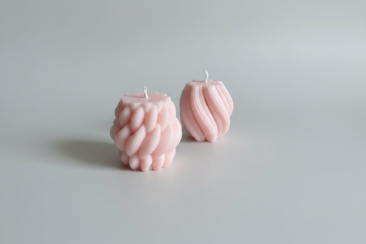Bougie parfumée artisanale tressée rose sur fond blanc