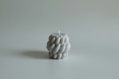 Bougie parfumée artisanale tressée gris sur fond blanc