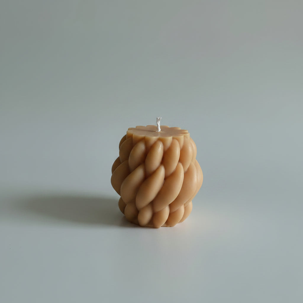 Bougie parfumée artisanale tressée marron sur fond blanc