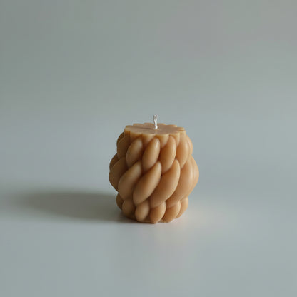 Bougie parfumée artisanale tressée marron sur fond blanc